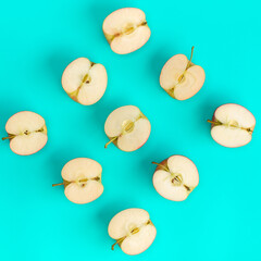Fruit pattern of apple halves over blue background. Flat lay, top view. Food background. .  Pop art design, creative summer concept.