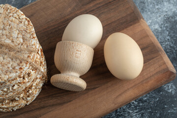 Puffed rice cakes and eggs on wooden board