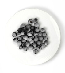 Organic frozen aronia berries on white background