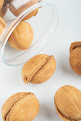 A glass jar full of sweet walnut shaped cookies