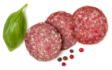 Slices of salami isolated on white background closeup. Sausage and basil leaves top view..