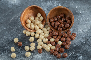 Wooden bowls with sweet corn balls on a gray background