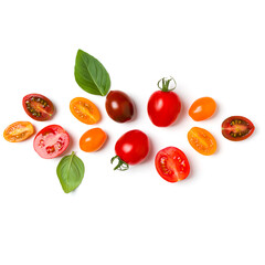 various colorful tomatoes and basil leaves isolated on white background. Top view, flat lay. Creative layout...