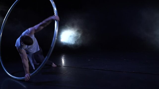 Circus artist dancing with cyr wheel. concept of concentration, willpower, and movement 