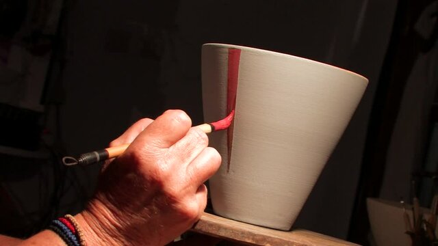 Patmos Greece artist paints handmade vases in pottery workshop