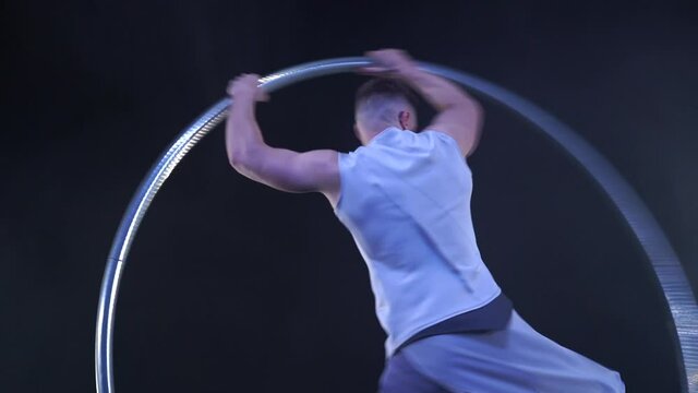 Circus artist dancing with cyr wheel. concept of concentration, willpower, and movement 
