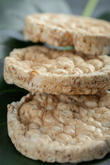 Three puffed rice cakes on green leaf
