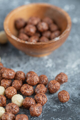 A wooden bowl with sweet corn balls on a gray background