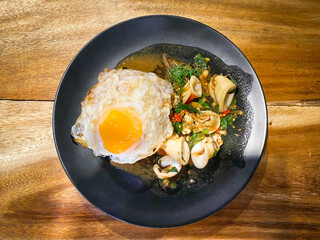 Rice topped with stir-fried squid and basil with fried egg