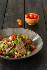 Beef salad with various vegetables served on a ceramic plate.