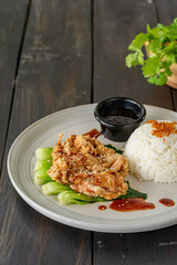 Crispy soy sauce-flavored chicken rice topped with sesame seeds served with bok choy
