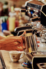 mano de joven tapaboca en maquina de expresso sirviendo un cafe