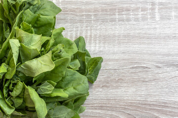 spinach leaves isolated on a wooden table with copy space in Brazil