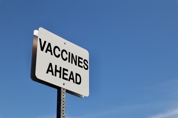 Vaccines Ahead sign against blue sky 