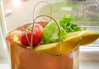 Paper bag with food delivered to people in need at home, the concept of charitable assistance, fast...