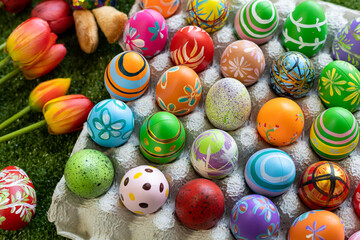 Fototapeta na wymiar Easter holiday concept,Colorful Easter eggs in egg box,basket Easter eggs,candy basket,rabbit doll in green grass background with space.