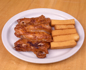 
Fried chicken with fried polenta served on white plate