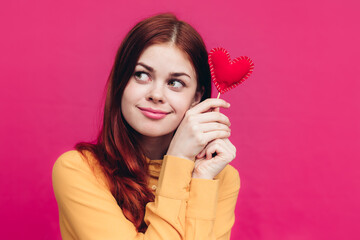 Valentine's day gifts woman with heart on stick on pink background