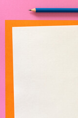 Fondo colorido naranja y rosa, minimalista, con lápiz azul y hoja en blanco