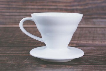 White cone coffee dripper on wooden background 
