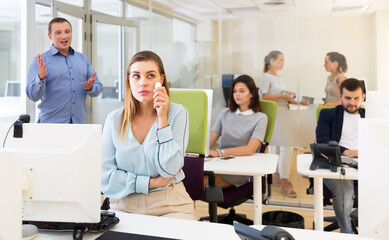 Obraz premium Disgruntled manager expressing dissatisfaction with work of frustrated young woman in modern office