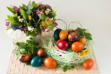 Easter eggs and spring flowers on white background