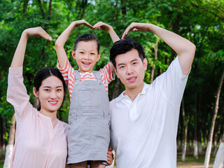 Happy family of three playing in the park