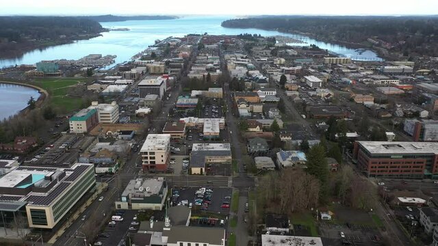 Cinematic aerial dolly drone footage, bird's eye view of downtown Olympia, East Bay, West Bay, Entrance Channel, stores and offices in the historic district of Olympia, Washington