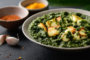 Palak Paneer indian traditional food with cheese and spinach on black background, selective focus