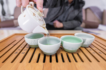 The Chinese family making tea at home with traditional tea set and colorful tea cup