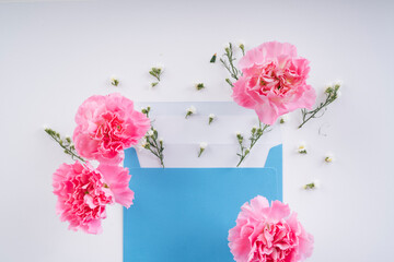 Pink blossom flower with blue mock up enclosed letter over white background.