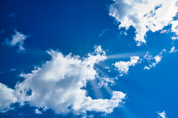 太陽光線と流れてゆく白い雲