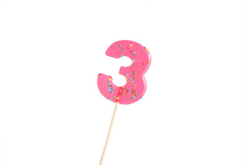 lolipop in number 3 shape. sweet candy on wooden stick. pink number 5 isolated on a white background. anniversary selebration or birthday party.