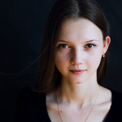 portrait of a young woman in black background