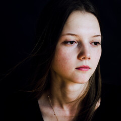 portrait of a young woman in black background