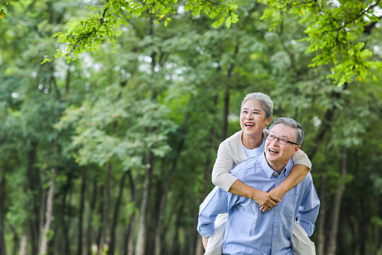 Old man looking at the scenery with his wife behind his back in the park