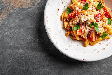 Pasta penne with tomato sauce, chicken meat and tomatoes served with parmesan cheese. Food recipe background. Close up. Italian food. Top view