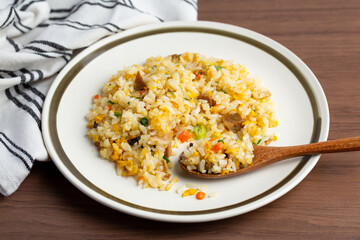 五目チャーハンと木のテーブル