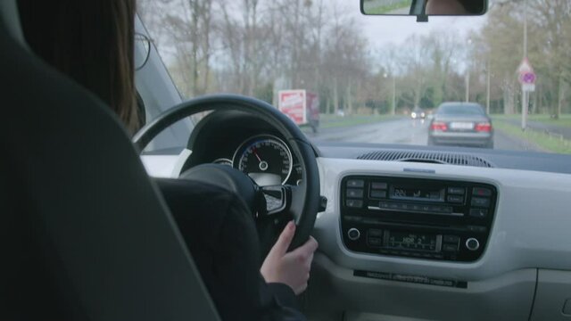 handheld footage of a woman driving in an electric car
