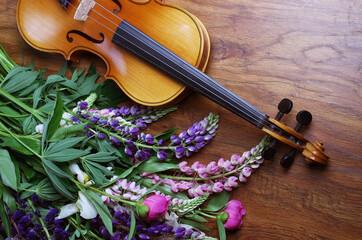 Fototapeta premium Violin and a bouquet of garden flowers on a wooden table.