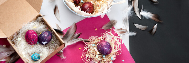 Painted Easter eggs in cardboard box and basket