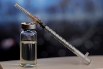 COVID-19 vaccine in a lab, close-up ampoule of vaccine with syringe, medical concept vaccination, fight against virus СOVID-19 corona virus, SARS-CoV-2 Vaccination, corona virus picture on background