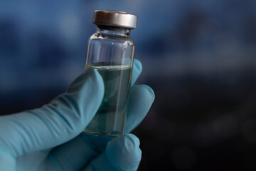 A doctor or scientist holding vaccine in a lab, close-up ampoule of vaccine vial dose, medical concept vaccination, fight against virus СOVID-19 corona virus