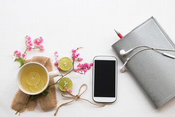 notebook planer,mobile phone for business work with healthy drinks honey lemon cocktail drinks water for health care for relax arrangement flat lay style on background white 