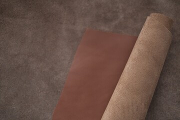 Brown genuine leather roll.real leather set. Leather in rolls on a blurred brown leather...