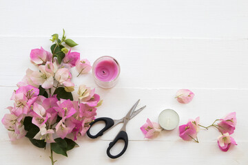 pink flowers bougainvillea in basket  ,candle  arrangement flat lay style on background white wooden