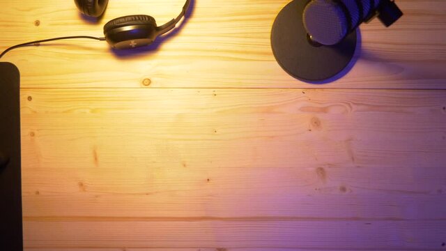 Content Creator is putting away an Recording Device on an wooden table for recording an Podcast