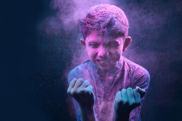 Portrait of a boy plays with colours. Concept for Indian festival Holi