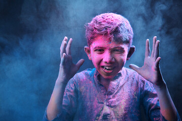 Portrait of a boy plays with colours. Concept for Indian festival Holi