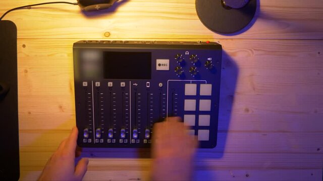 Content Creator is putting an Recording Device on an wooden table for recording an Podcast